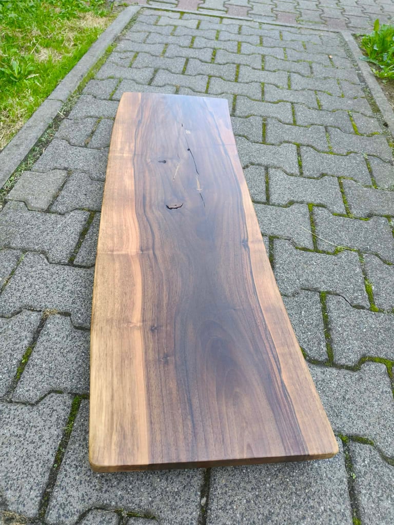 Wooden plank with natural grain and knots on a brick paved driveway with grass border