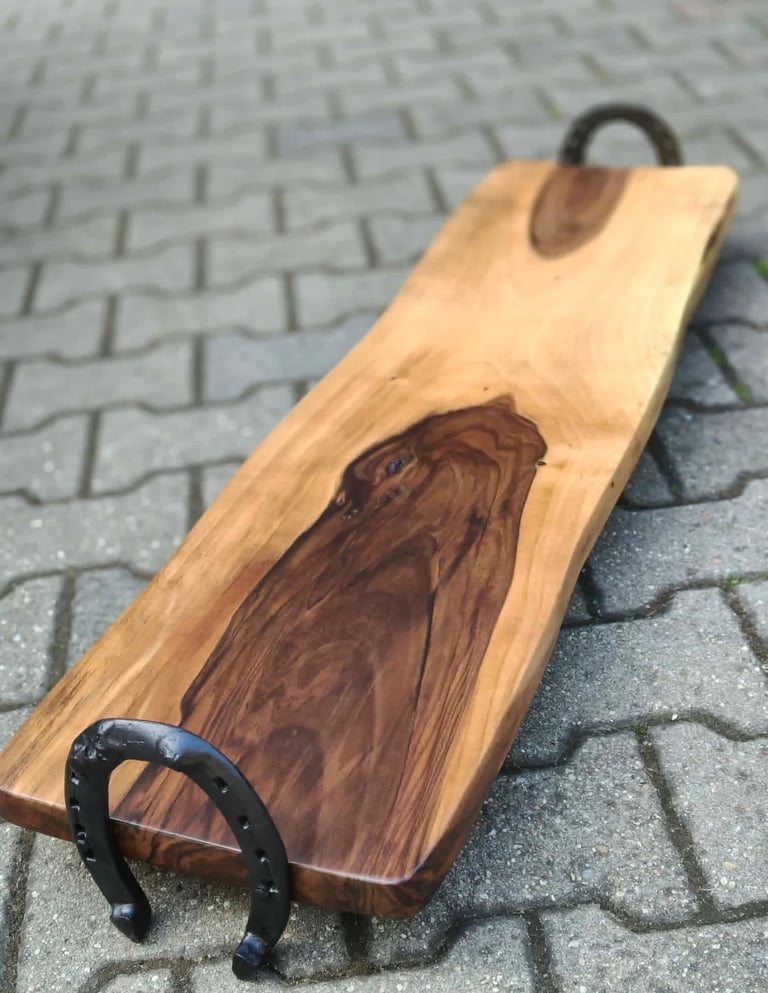 Wooden cornhole board with eagle design and black metal handles on brick surface